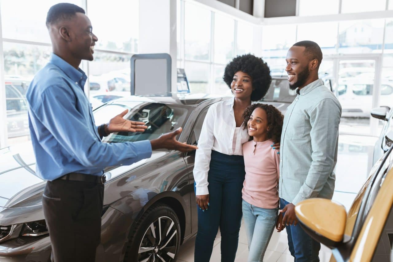 car-purchase-or-rental-millennial-family-with-kid-speaking-to-salesman